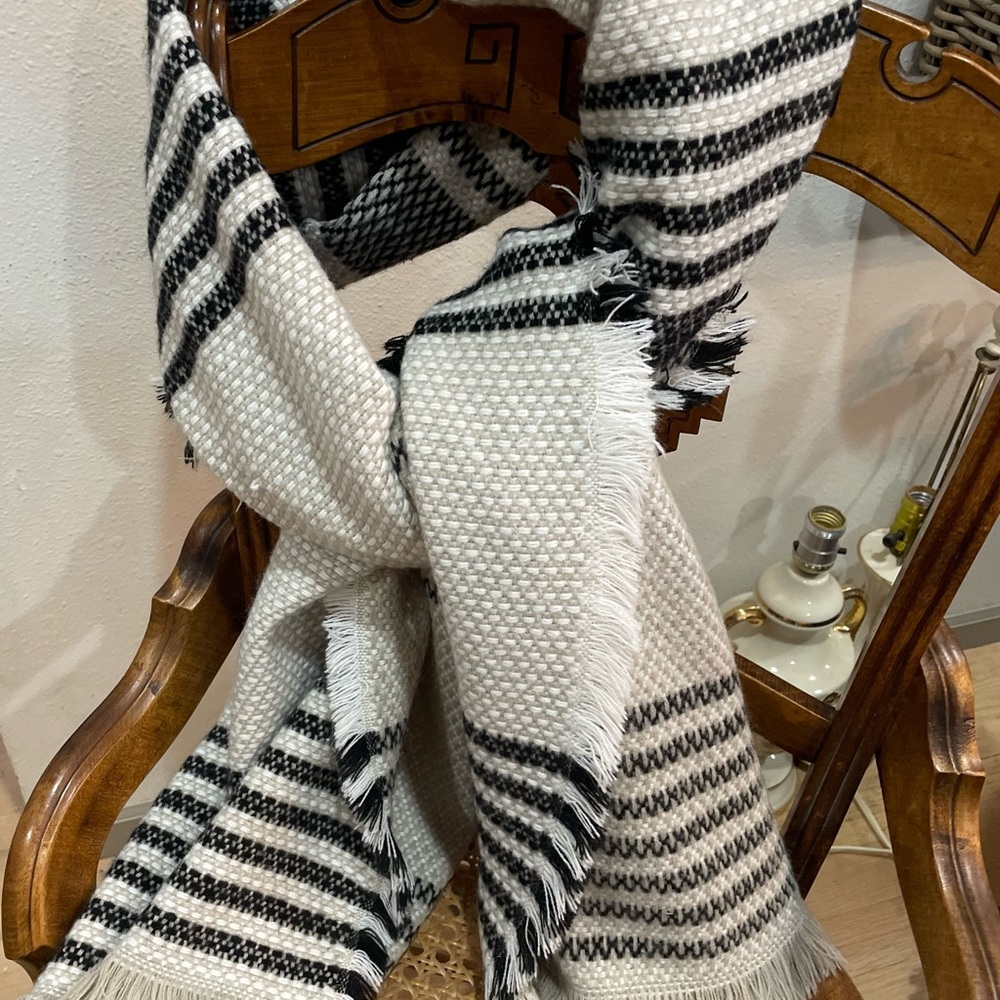 Shawl/wrap in black stripe with cream / gray background.